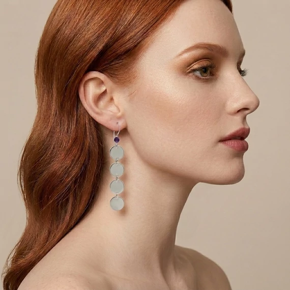 A modell az ametiszt hosszú korong fülbevalót viseli