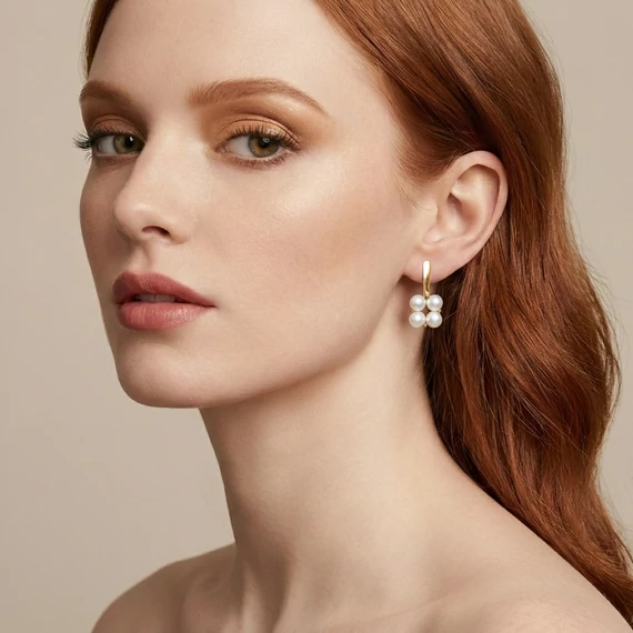 A modell a Quartet pearl tenyészett gyöngy fülbevalót viseli